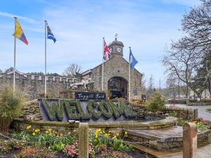 a welcome sign in front of a building with a clock tower at Stable Cottage - Uk51669 in Leyburn