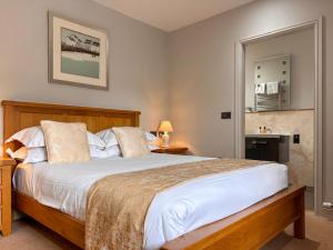 a bedroom with a large bed with white sheets at Stable Cottage - Uk51669 in Leyburn +15 photos