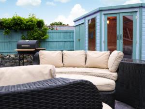 a couch sitting on a patio next to a house at Llywnfor in Morfa Nefyn