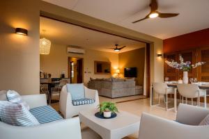 a living room with white chairs and a couch at Luxury Ocean View Apartment, Private Beach, Infinity Pool, near Jan Thiel C3 in Willemstad