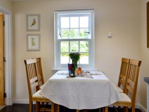 a dining room table with a vase of flowers on it at The Old Gasworks Building in Montrose