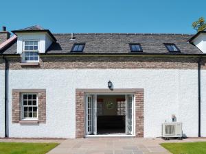 a white brick house with an open door at The Old Gasworks Building in Montrose