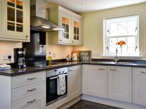 a kitchen with white cabinets and black counter tops at The Old Gasworks Building in Montrose