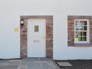 a white door on a brick building with a window at The Old Gasworks Building in Montrose +17 photos