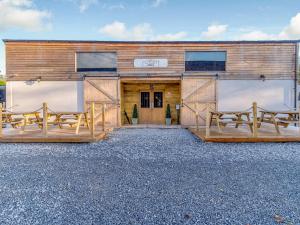 a building with three picnic tables in front of it at Owls Rest - Iua in Cayton