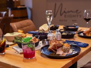 a table with a plate of food and wine glasses at Owls Rest - Iua in Cayton +10 photos