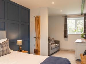 a bedroom with a bed and a couch and a window at Dovecote House-Uk30233 in Cayton
