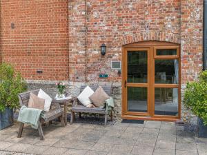 a patio with two chairs and a table with pillows at Byre - Uk49899 in Blandford Forum