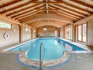 a swimming pool in a house with a wooden ceiling at Byre - Uk49899 in Blandford Forum