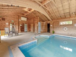 an indoor swimming pool in a wooden building at Byre - Uk49899 in Blandford Forum
