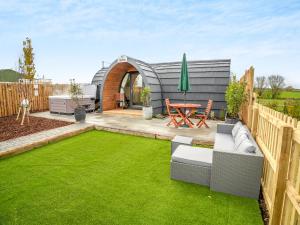 a garden with a circular patio with a table and grass at The Hive - Uk45565 in Longford