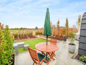 a patio with a table and chairs and an umbrella at The Hive - Uk45565 in Longford