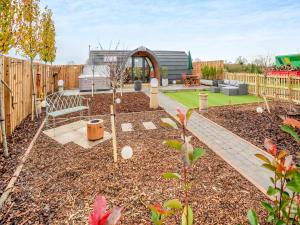 a garden with a bench and a fence at The Hive - Uk45565 in Longford +21 photos
