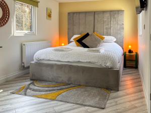 a bedroom with a large bed with a large headboard at Ashtree Hideaway in Brandon