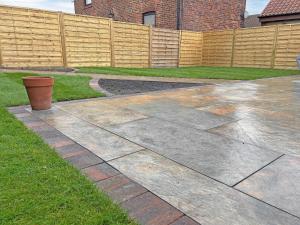 a concrete driveway in a yard with a fence at Ashtree Hideaway in Brandon