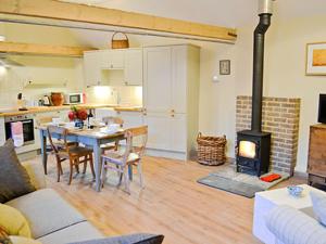 a living room with a table and a fireplace at Ox Lodge Barn - Pqqw in Battle