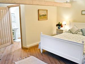 a bedroom with a white bed and a bathroom at Ox Lodge Barn - Pqqw in Battle