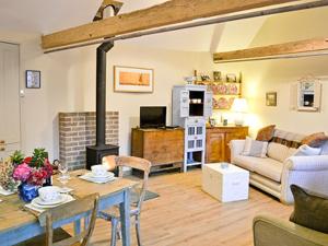 a living room with a table and a fireplace at Ox Lodge Barn - Pqqw in Battle