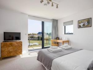 a bedroom with a bed and a tv and a window at Willowmere in Dorchester