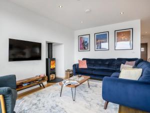 a living room with a blue couch and a fireplace at Willowmere in Dorchester