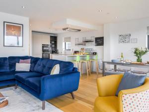 a living room with a blue couch and a kitchen at Willowmere in Dorchester +26 photos