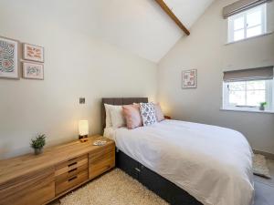 a bedroom with a large bed and a wooden dresser at Gardeners Cottage - Uk51831 in Great Ayton