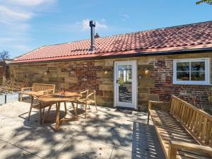 a patio with a table and chairs and a house at Gardeners Cottage - Uk51831 in Great Ayton