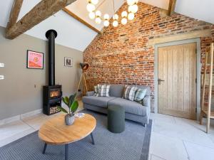 a living room with a couch and a brick wall at Gardeners Cottage - Uk51831 in Great Ayton +12 photos