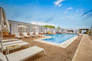 a pool at a resort with white chairs and a swimming pool at Armeno Resort in Marathias