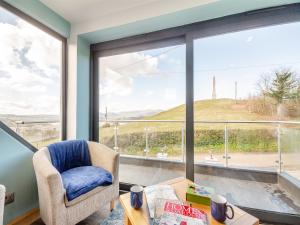 a room with a large window with a chair and a table at Blodfryn in Llandudno Junction