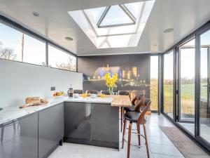 a kitchen with a table and chairs and windows at Blodfryn in Llandudno Junction