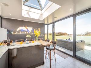 a kitchen with a table and chairs and a large window at Blodfryn in Llandudno Junction
