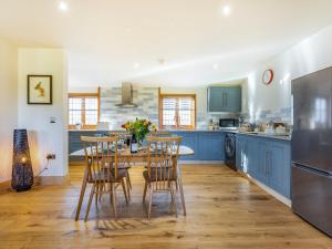 a kitchen with blue cabinets and a table and chairs at Snowdrop Lodge -Uk32959 in Molash