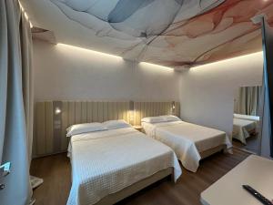 two beds in a room with a painting on the ceiling at Feel Good in Rimini +32 photos