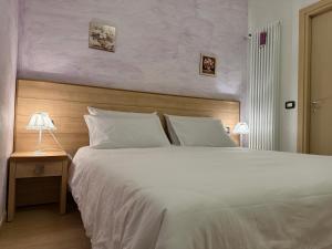 a bedroom with a large bed and a table with a lamp at Le Essenze - Agriturismo con vista in Cesena