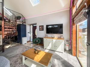 a living room with a television and a table at West Mains Barn - Uk51957 in Kilbirnie