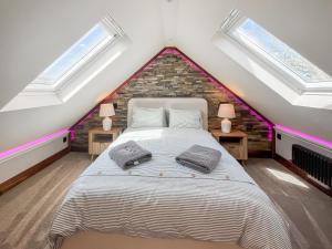 a bedroom with a large bed in a attic at West Mains Barn - Uk51957 in Kilbirnie