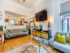 a living room with a couch and a tv at Jorvik Villas in York