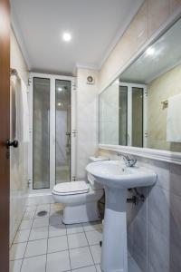 een witte badkamer met een toilet en een wastafel bij Golden Place Apartment in Funchal +12 foto's