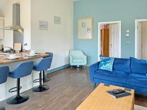 a living room with a blue couch and a table at Jasmine Lodge in Garton