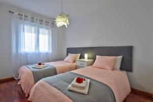twee bedden in een kamer met roze en grijs bij Golden Place Apartment in Funchal