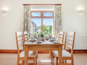 a dining room with a table and chairs and a window at Hayloft - Uk49909 in Blandford Forum