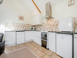 a white kitchen with white cabinets and appliances at Hayloft - Uk49909 in Blandford Forum