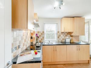 a kitchen with wooden cabinets and a sink at Anne's Cottage in Strines