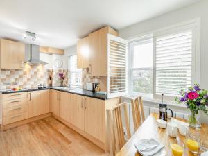 a kitchen with wooden cabinets and a wooden table at Anne's Cottage in Strines +21 photos