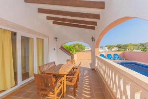 a dining room with a table and chairs on a balcony at Villa Mares in Cala en Porter