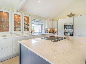 a kitchen with white cabinets and a large island at Uk34190 - Gowan View in Arkholme
