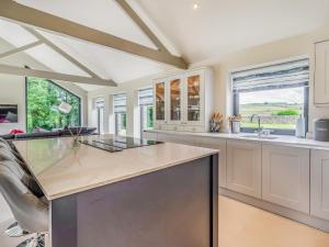 a kitchen with white cabinets and a large island at Uk34190 - Gowan View in Arkholme