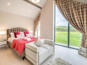 a bedroom with a bed and a chair and a window at Uk34190 - Gowan View in Arkholme +17 photos
