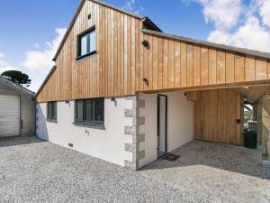a house with a wooden roof and a garage at The Old Coach Garage in Gerrans